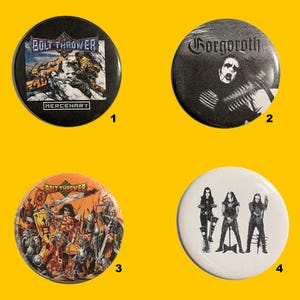 Puede incluir: Cuatro botones redondos de metal con diferentes diseños. Un botón presenta el texto "BOLT THROWER" y "MERCENARY" con una ilustración. Otro tiene el nombre de la banda "Gorgoroth". Los otros dos botones tienen ilustraciones de miembros de la banda.