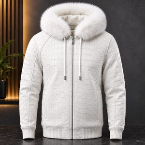 Puede incluir: Una chaqueta blanca con capucha que presenta un patrón texturizado de piel de cocodrilo, un borde grueso de piel sintética blanca en la capucha, un cierre central de cremallera plateada y puños y dobladillo de punto acanalado.