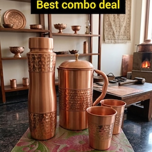 Puede incluir: Un conjunto de utensilios de cocina de cobre, que incluye una botella de agua, una jarra y dos tazas, con una textura martillada. Los artículos se exhiben sobre una superficie con estampado floral. El texto "Best combo deal" se muestra en un recuadro negro.