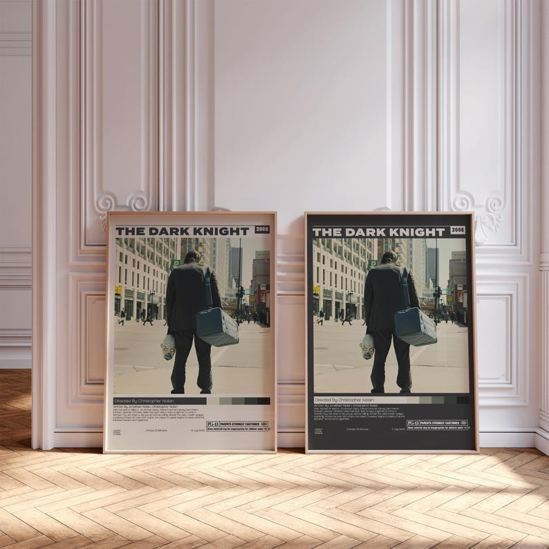 May include: Two framed movie posters for The Dark Knight 2008. Each poster features a central image of a person in a dark suit carrying a bag and a mask, walking down a city street. The text includes the title, director, and production details.