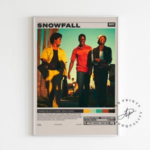 May include: A framed poster featuring three people walking. The poster has the title "SNOWFALL" and the year "2017" at the top. The people are dressed in casual clothing. The poster has a retro design with a color palette of yellow, red, and blue.