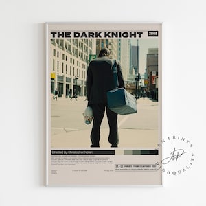 Könnte beinhalten: Gerahmtes Filmplakat für "The Dark Knight" (2008). Es zeigt eine Person im Anzug, die eine Maske und eine Tasche hält und eine Stadtstraße entlanggeht. Das Poster hat eine neutrale Farbpalette mit Text oben und unten.