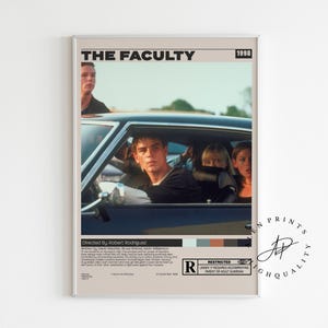 May include: A framed movie poster for "The Faculty" (1998) featuring a car with several people inside. The poster has a beige background with the movie title and the year in black text. The poster includes the director's name and a rating.