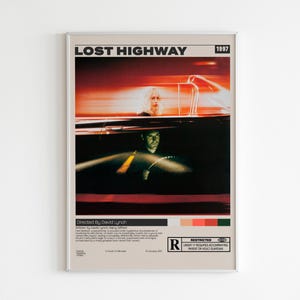 May include: A rectangular wall poster for the 1997 film Lost Highway, directed by David Lynch. The design features a motion-blurred red and black scene of a car interior, with text details, a color palette, and an R-rating symbol at the bottom.