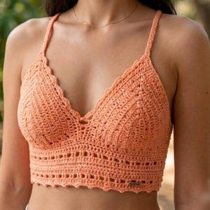 Può includere: Top all'uncinetto color pesca con scollatura smerlata e spalline sottili. Il top fatto a mano presenta un motivo a punto dettagliato e una silhouette aderente, perfetto per la stagione calda. Il top è un capo elegante e confortevole.