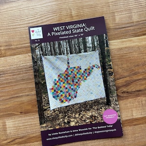 May include: A pattern for a pixelated quilt of West Virginia, with a finished size of 65" x 75". The cover features a colorful quilt in the shape of the state. The text reads "West Virginia: A Pixelated State Quilt".