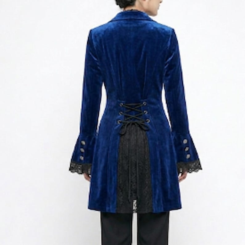 May include: A long, royal blue velvet coat with a black lace panel down the back. The coat features buttoned, flared sleeves with black lace trim and a corset-style back. The coat is a gothic style.