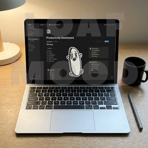 Puede incluir: Un portátil plateado que muestra una interfaz de "Productivity Dashboard" con una pegatina de fantasma triste. Una taza negra y un lápiz óptico están sobre el escritorio de madera. El teclado del portátil es visible.