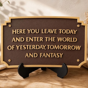 Peut inclure: Une plaque rectangulaire marron avec une bordure dorée et des lettres dorées indiquant : HERE YOU LEAVE TODAY AND ENTER THE WORLD OF YESTERDAY, TOMORROW AND FANTASY. La plaque présente quatre petits accents floraux dorés aux coins et repose sur un support noir.
