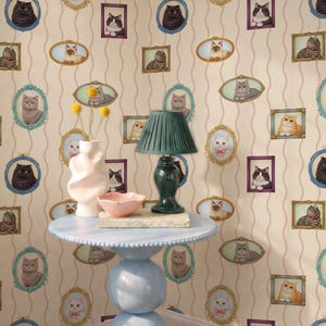 Pode incluir: Uma cena interior caprichosa com uma mesa azul clara, uma lâmpada, um vaso e uma tigela. O papel de parede é adornado com retratos de gatos emoldurados. A lâmpada tem uma sombra verde e o vaso contém flores amarelas. A mesa tem 60 cm de diâmetro.