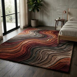 May include: A rectangular area rug featuring a textured, three-dimensional wave pattern in a gradient of warm earth tones, including deep burgundy, burnt orange, terracotta, chocolate brown, and soft beige, creating a flowing, layered visual effect.