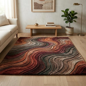 May include: A rectangular area rug featuring a textured, three-dimensional wave pattern in a gradient of warm earth tones including deep rust, burnt orange, muted brown, and charcoal gray, creating a flowing, layered visual effect across the surface.
