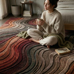 Soft hand tufted wool rug close-up with person sitting cozy abstract wave pattern rug earth tone luxury handmade carpet