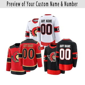 May include: A collection of hockey jerseys in red, black, and white. Each jersey features the number "00" and the text "ANY NAME" on the back. The jerseys also display a team logo and are long-sleeved.