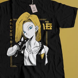 May include: Black t-shirt featuring a graphic of a female anime character with blonde hair and blue eyes. The design includes the text "ANDROID" and "NO. 18" in gold. A tag is attached to the shirt.