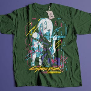 May include: Dark green t-shirt featuring a graphic of a female anime character with white hair and blue accents. The shirt has the text "CYBERPUNK EDGERUNNERS" in yellow and red. The word "LUCY" is printed multiple times on the shirt.
