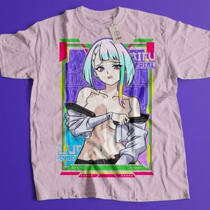 Puede incluir: Camiseta rosa claro con un gran gr&aacute;fico de un personaje de anime con cabello azul y verde. El gr&aacute;fico incluye texto en japon&eacute;s e ingl&eacute;s, con un borde verde ne&oacute;n y rosa. Una etiqueta dice "LARGE".