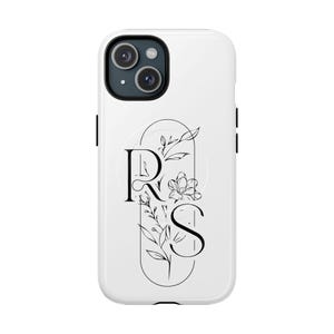 May include: White phone case with a black camera module. The case features a black and white floral design with the letters "R" and "S" in a decorative font. The design is enclosed in an oval shape.