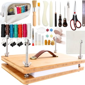 May include: A bookbinding kit featuring a wooden press with metal hardware, a white zippered pouch, assorted colorful thread spools, needles, awls, bone folders, a brush, scissors, a metal ruler, binder clips, thimbles, and fabric swatches.