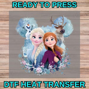 Op de afbeelding: Een DTF-warmteoverdracht met Elsa en Anna uit Frozen, vergezeld door Olaf en Sven. De personages staan tegen een blauwe aquarelachtergrond in de vorm van muizenoortjes, geaccentueerd met bloemelementen en de tekst READY TO PRESS.