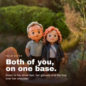 May include: A custom figurine of a couple standing on a single base. The male figure has silver hair and wears a grey polo shirt with dark pants. The female figure has curly reddish-brown hair, wears glasses, a white top, black jacket, and a shoulder bag.