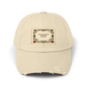 May include: A beige distressed baseball cap featuring a rectangular graphic on the front. The graphic displays a floral border with various insects and the text: Call me when the bugs don't die and the spring looks just like autumn.