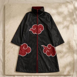 May include: A black long-sleeve coat featuring a high collar and a full-length front zipper. The garment is decorated with three large, stylized red clouds with white outlines positioned on the chest and lower front panels of the coat.