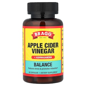 Op de afbeelding: Een bruine fles Bragg appelciderazijn capsules. Het etiket is geel met de merknaam en productinformatie in zwarte en witte tekst. Het etiket bevat ook de woorden "Balance" en "90 Capsules".