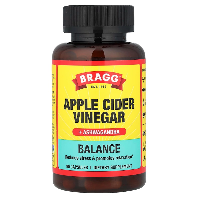 Op de afbeelding: Een bruine fles Bragg appelciderazijn capsules. Het etiket is geel met de merknaam en productinformatie in zwarte en witte tekst. Het etiket bevat ook de woorden "Balance" en "90 Capsules".