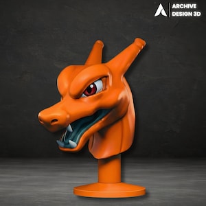 May include: A 3D-printed orange Charizard head statue with red eyes and a teal mouth. The statue is mounted on a round orange base. The Archive Design 3D logo is in the upper right corner.