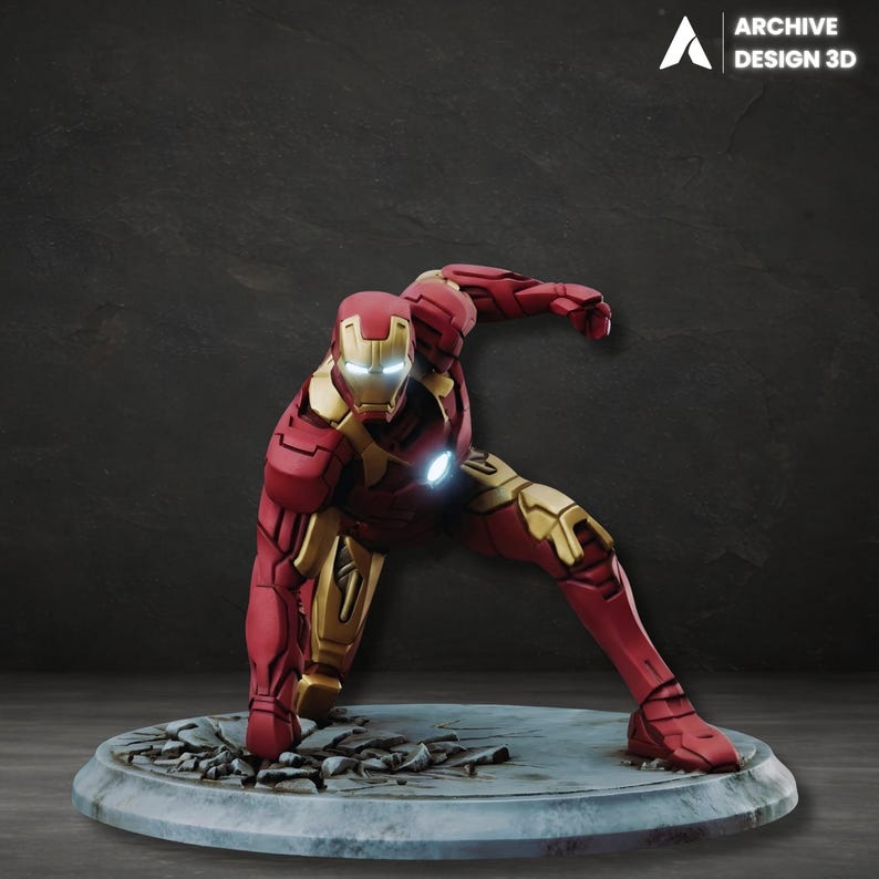 May include: A red and gold Iron Man figurine in a dynamic pose, kneeling on a gray circular base with a cracked surface. The figurine has glowing white eyes and chest piece. The Archive Design 3D logo is in the top right corner.
