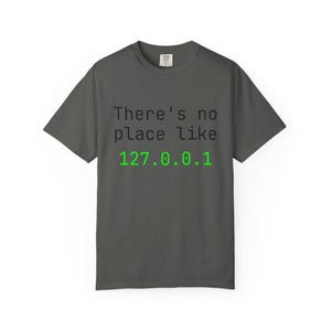 May include: Dark gray t-shirt with the text "There's no place like 127.0.0.1" printed in black and green. The shirt is a short-sleeved crew neck.