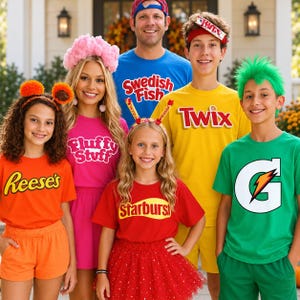 Pode incluir: Um grupo de pessoas vestindo camisetas temáticas com logotipos de doces e bebidas, incluindo Reese's, Fluffy Stuff, Swedish Fish, Twix, Starburst e Gatorade. Os trajes incluem shorts, saias e tiaras coloridas combinando com acessórios.