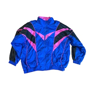 May include: A vintage blue track jacket with black and pink accents. The jacket features a full zipper, a pink collar, and elastic cuffs. The design includes black and pink angled stripes across the chest and sleeves, creating a retro aesthetic.