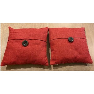 Juego de 2 cojines decorativos con aspecto de arpillera roja y detalles de botones, 43 cm x 43 cm.