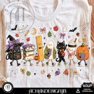 Op de afbeelding: Een wit t-shirt met een kleurrijke grafische print van antropomorfe schoolspullen en Halloween-figuren, waaronder een rugzak, boeken, een liniaal, een spook, een zwarte kat, een koffiebeker en een pompoen, allemaal met sneakers aan.
