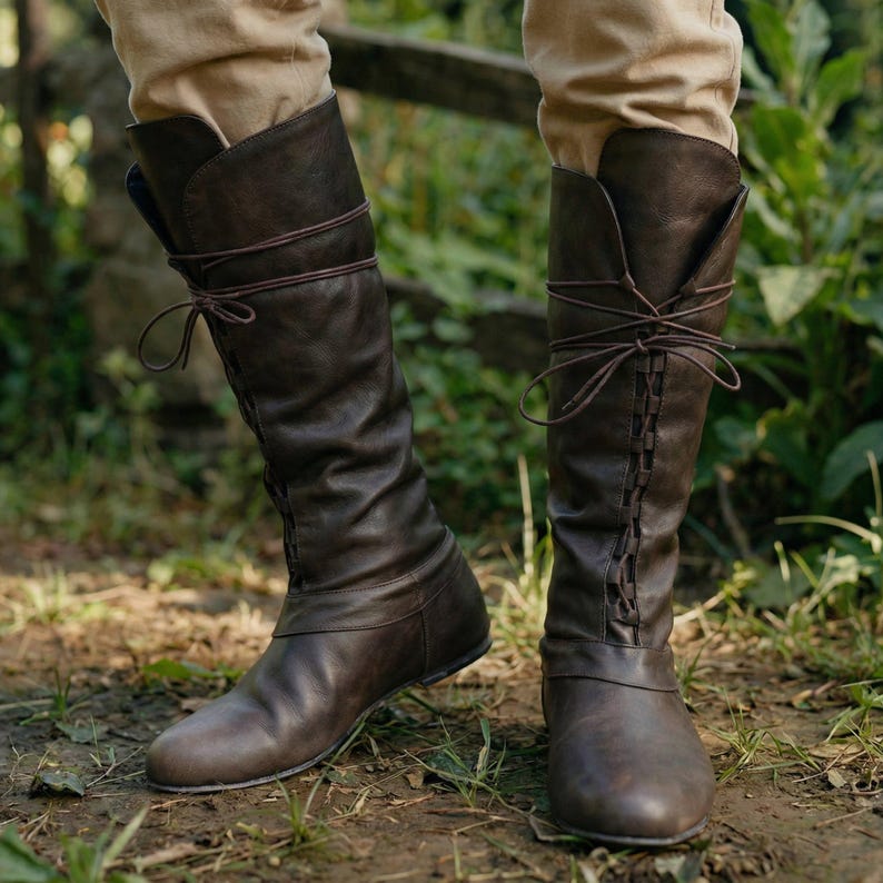 Puede incluir: Botas altas de cuero marr&oacute;n con dise&ntilde;o de cordones y parte superior doblada. Las botas tienen un aspecto ligeramente desgastado y se usan al aire libre.