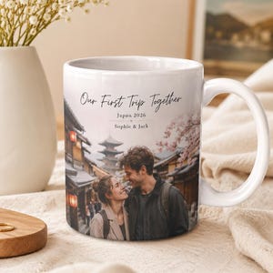 Puede incluir: Taza de cer&aacute;mica blanca con una fotograf&iacute;a de una pareja en Jap&oacute;n, con el texto "Our First Trip Together", "Japan 2026" y los nombres "Sophie & Jack". La taza tiene un asa curva y est&aacute; sobre un fondo suave y neutro.