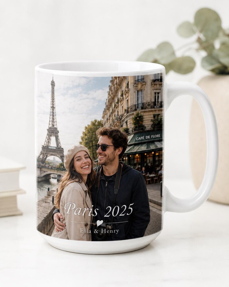 Peut inclure: Mug en c&eacute;ramique blanche avec une photo d'un couple &agrave; Paris, avec la Tour Eiffel en arri&egrave;re-plan. Le mug porte l'inscription "Paris 2025" et les noms "Ella & Henry".