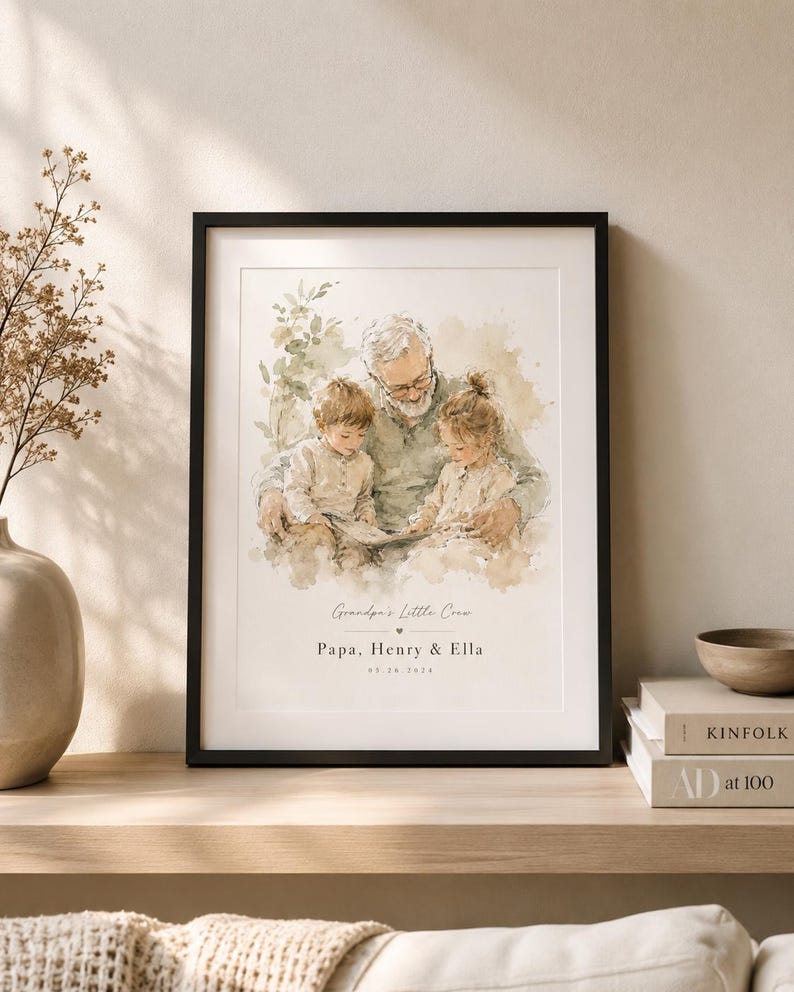 May include: A framed watercolor print featuring a grandfather with two grandchildren. The print has a black frame and includes the text "Grandpa's Little Crew, Papa, Henry & Ella, 05.24.2024". The artwork is displayed on a wooden shelf.