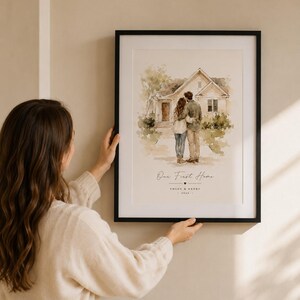 Puede incluir: Una impresi&oacute;n en acuarela enmarcada que representa a una pareja frente a una casa. La impresi&oacute;n tiene el texto "Our First Home" y los nombres "Chloe & Henry" con el a&ntilde;o 2024. El marco es negro.