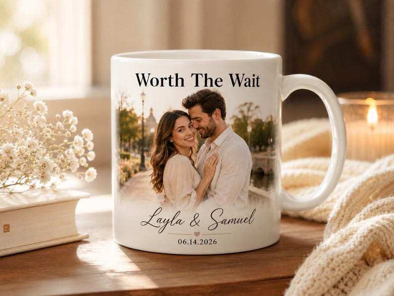 Op de afbeelding: Witte keramische mok met een foto van een stel, met de tekst "Worth The Wait", en de namen "Layla & Samuel" met de datum "06.14.2026". De mok heeft een gebogen handvat en een glanzende afwerking.