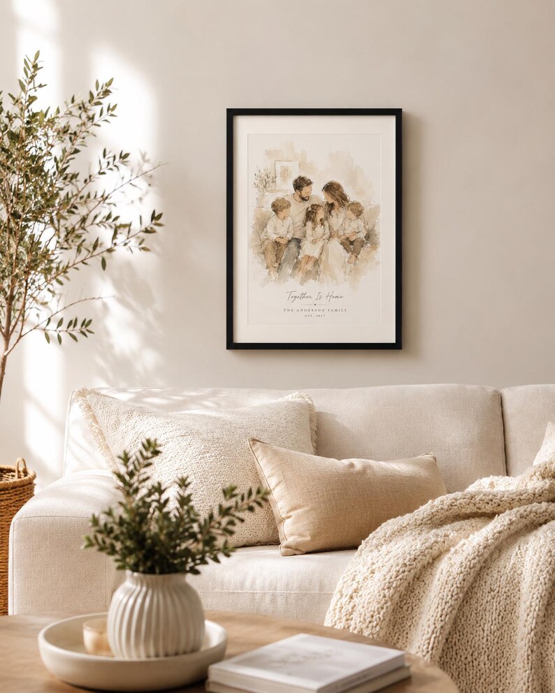K&ouml;nnte beinhalten: Ein gerahmtes Familienportr&auml;t mit schwarzem Rahmen h&auml;ngt &uuml;ber einem beigen Sofa. Das Kunstwerk im Aquarellstil zeigt eine f&uuml;nfk&ouml;pfige Familie. Der Text "Together Is Home" und der Familienname sind unter dem Bild aufgedruckt. Dekorative Kissen und eine Strickdecke liegen auf dem Sofa.