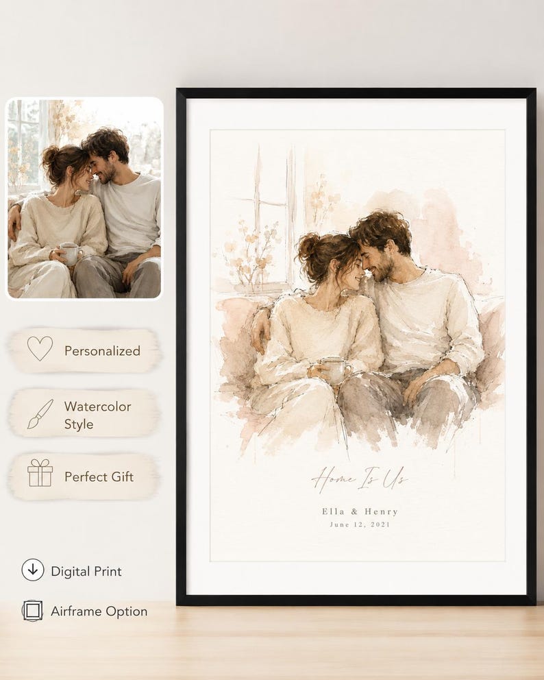 May include: A framed watercolor print featuring a couple embracing, with soft beige and brown tones. The print includes the text "Home Is Us," along with names and a date. The artwork is displayed in a black frame.