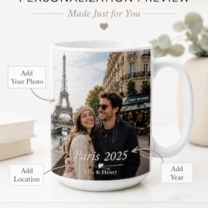 Peut inclure: Mug en c&eacute;ramique blanche avec une photo personnalis&eacute;e d'un couple &agrave; Paris, avec la Tour Eiffel en arri&egrave;re-plan. Le mug porte l'inscription "Paris 2025" et les noms "Ella & Henry". Un mug souvenir.