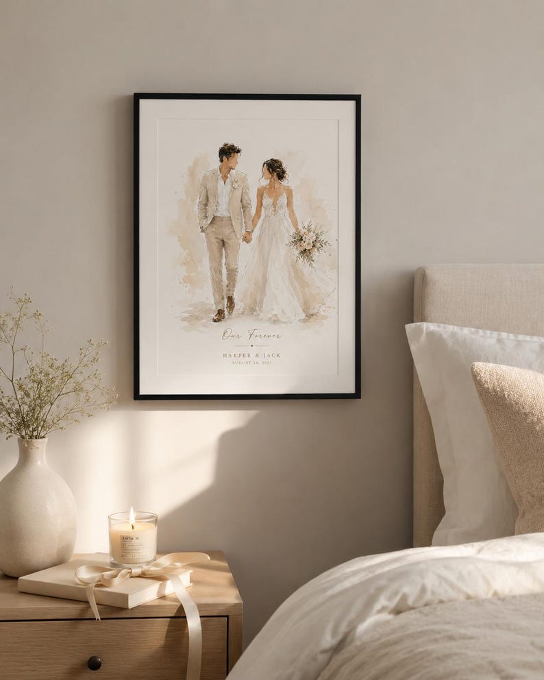 May include: A framed watercolor print of a couple holding hands, with the text "Our Forever" and names and a date. The artwork is in a black frame and is displayed on a wall. A nightstand with a candle and a vase of flowers is in the foreground.