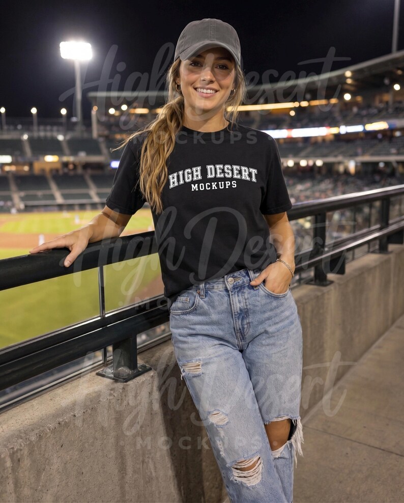 Peut inclure: Un t-shirt noir &agrave; manches courtes avec le texte blanc HIGH DESERT MOCKUPS imprim&eacute; sur la poitrine, associ&eacute; &agrave; une casquette de baseball grise et un jean en denim bleu clair us&eacute; avec des d&eacute;chirures aux genoux et aux cuisses.