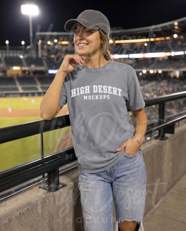 Peut inclure: Un t-shirt gris &agrave; manches courtes avec le texte blanc HIGH DESERT MOCKUPS sur la poitrine, associ&eacute; &agrave; une casquette de baseball grise assortie et un jean en denim bleu clair us&eacute;. Le t-shirt a un col rond et une coupe d&eacute;contract&eacute;e.