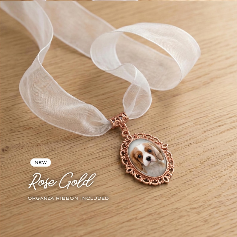 May include: A rose gold oval pendant featuring a portrait of a Cavalier King Charles Spaniel, suspended from a sheer white organza ribbon. The pendant has an ornate, filigree-style frame. Text on the image reads NEW Rose Gold ORGANZA RIBBON INCLUDED.