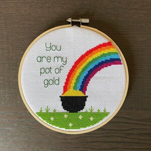 May include: A white embroidery hoop with a rainbow, a pot of gold, and the text "You are my pot of gold".
